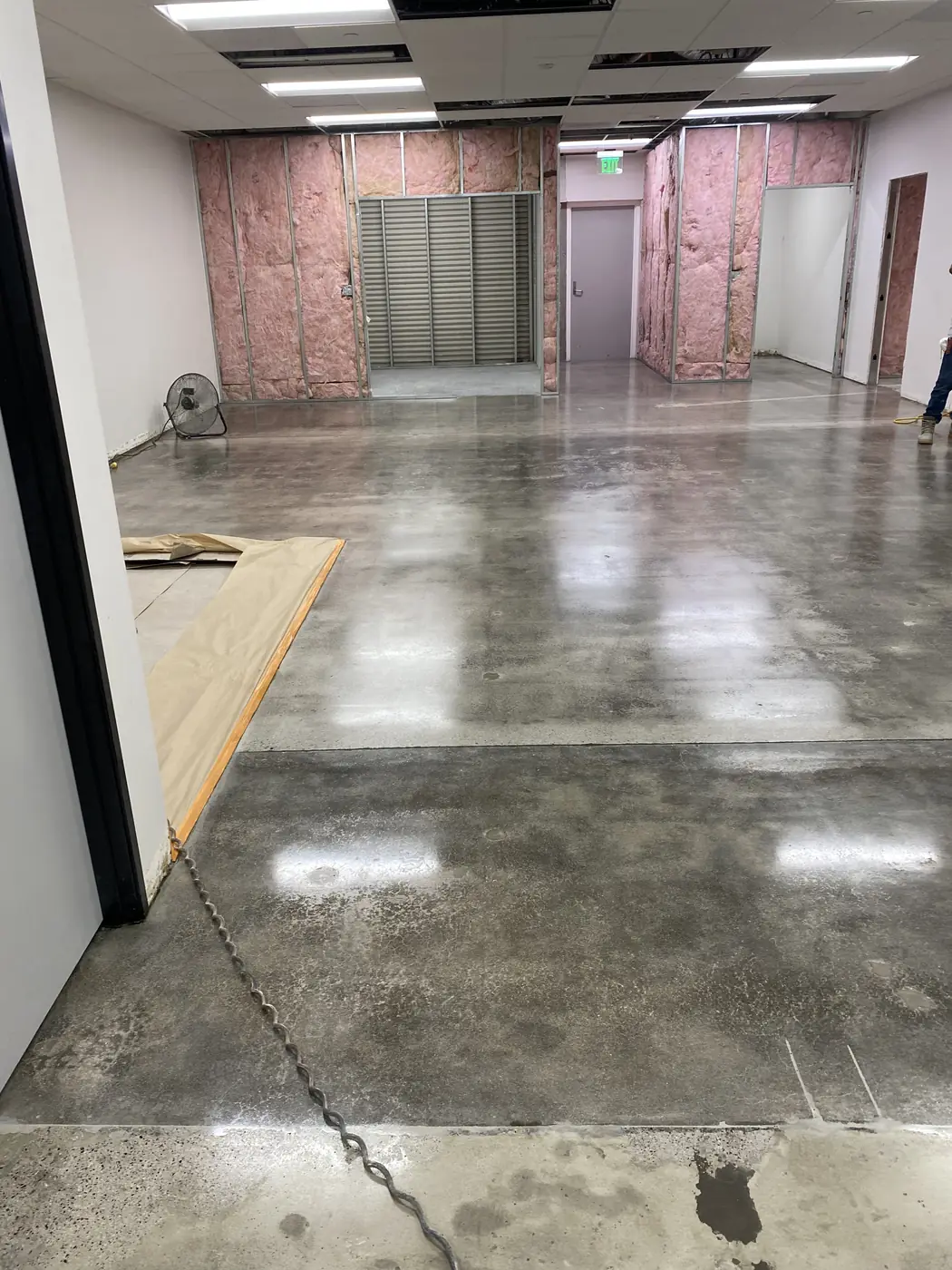 Polished concrete floor in a building under construction with framed walls