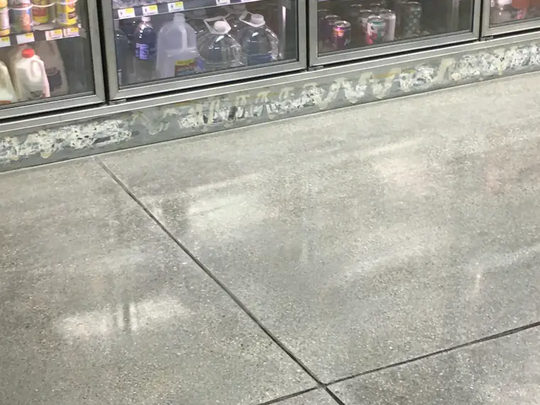 Polished concrete floor in a convenience store beside the drinks fridges
