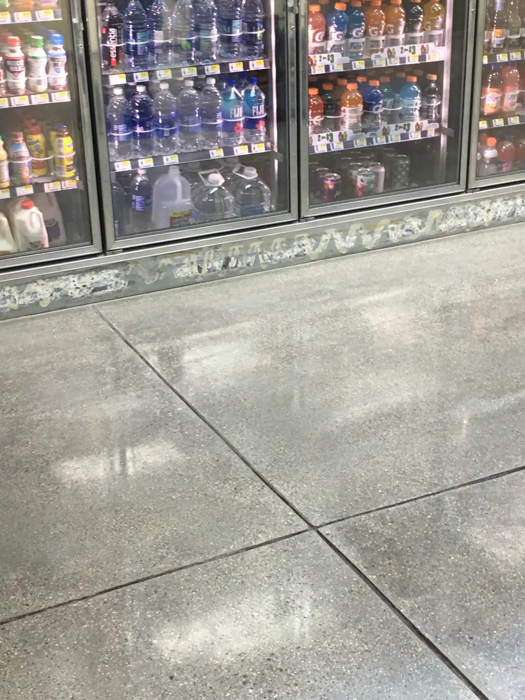 Polished concrete floor in a convenience store beside the drinks fridges