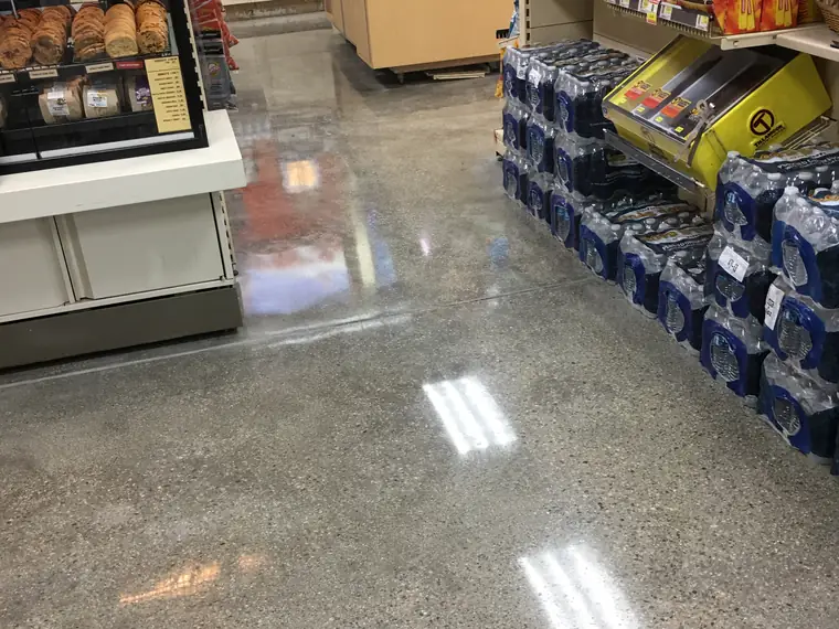 Polished concrete store floor with stacked drinks pallets and shelving
