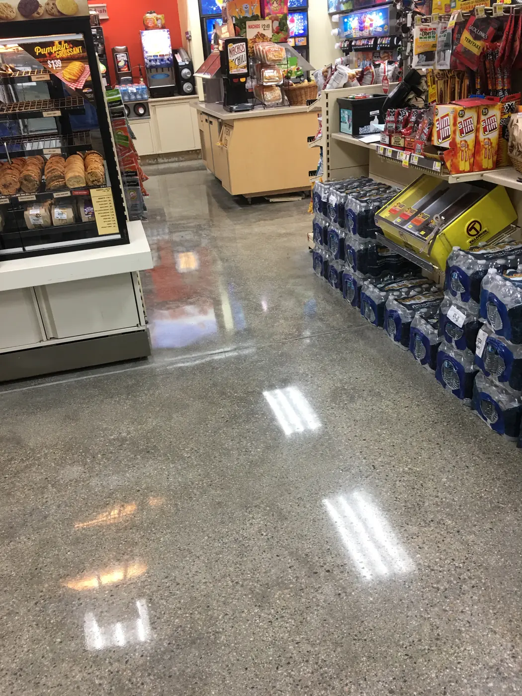 Polished concrete store floor with stacked drinks pallets and shelving