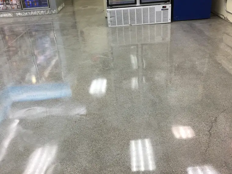 Polished concrete floor reflecting the lights in a convenience store aisle