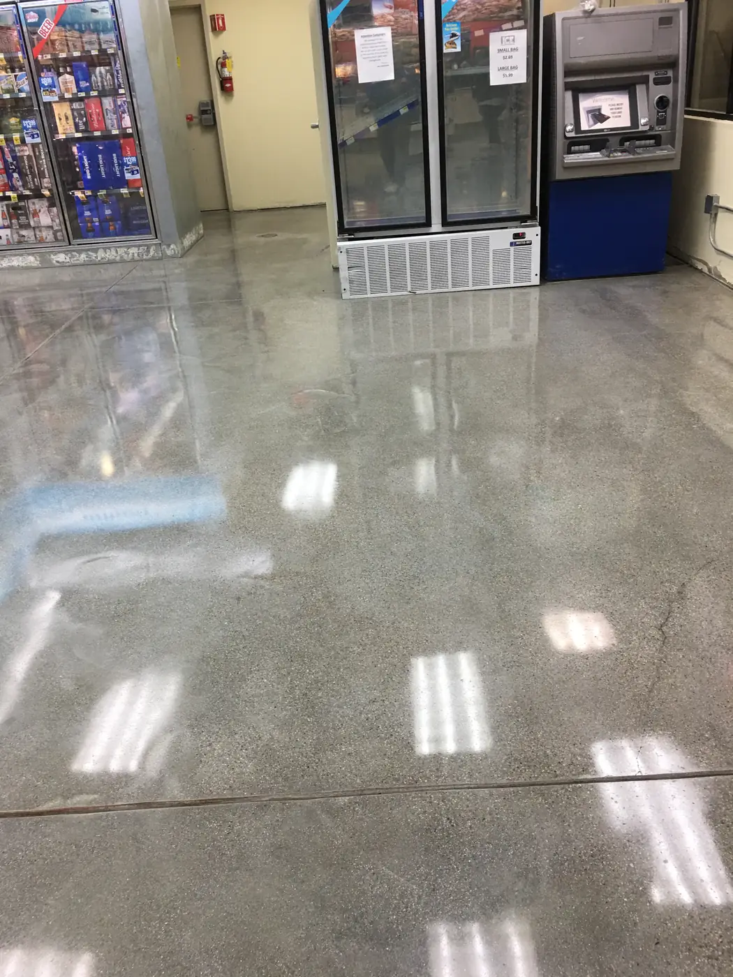 Polished concrete floor reflecting the lights in a convenience store aisle