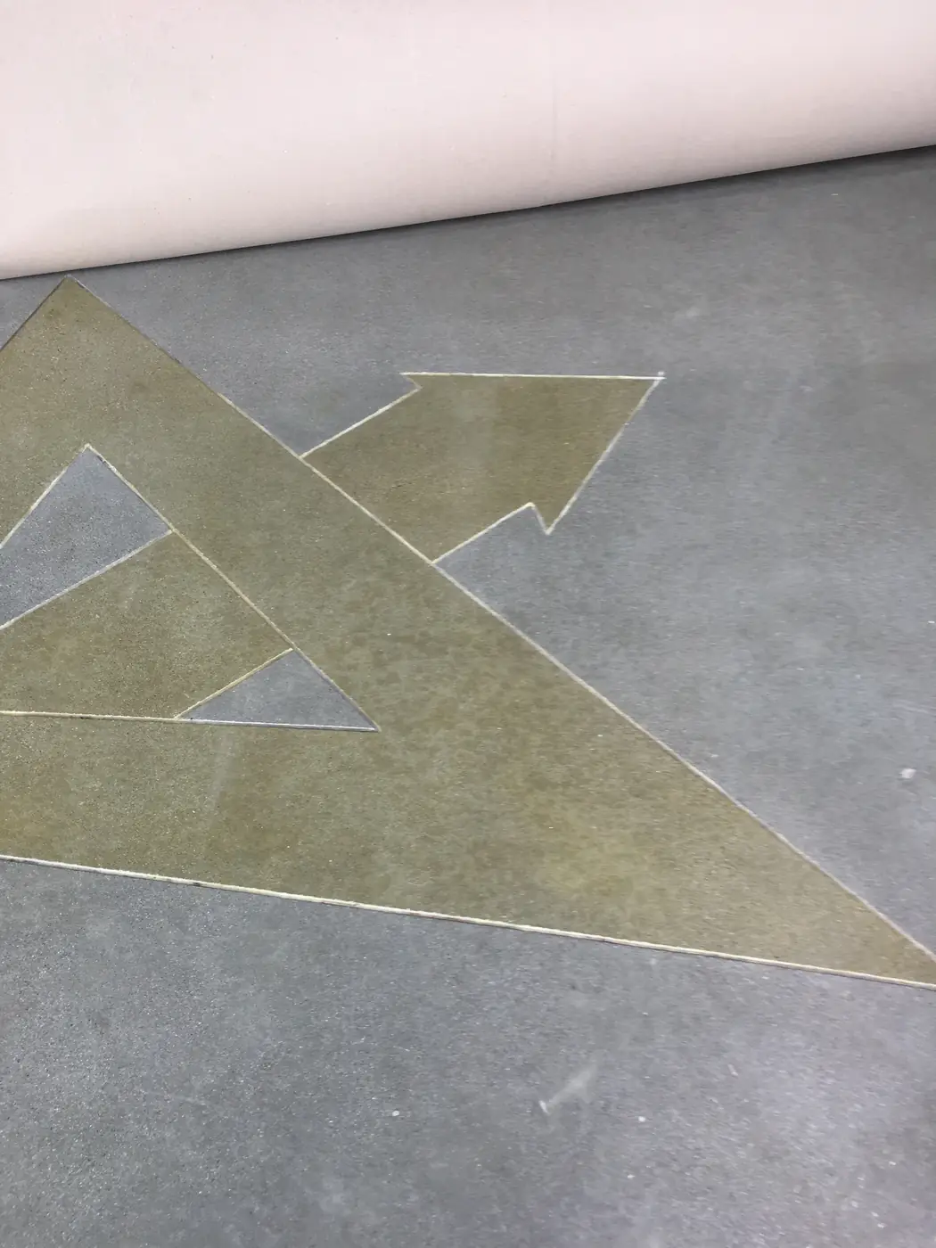 Polished concrete floor with a gold arrow graphic cut and stained into it