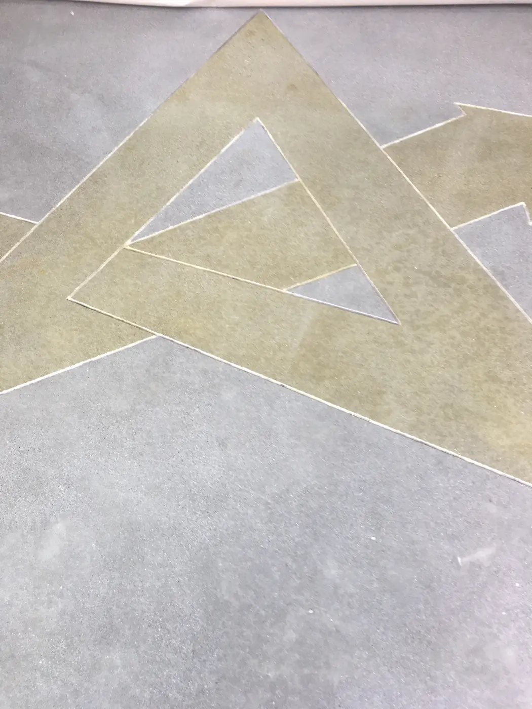 Gold stained geometric graphic set into a polished concrete floor