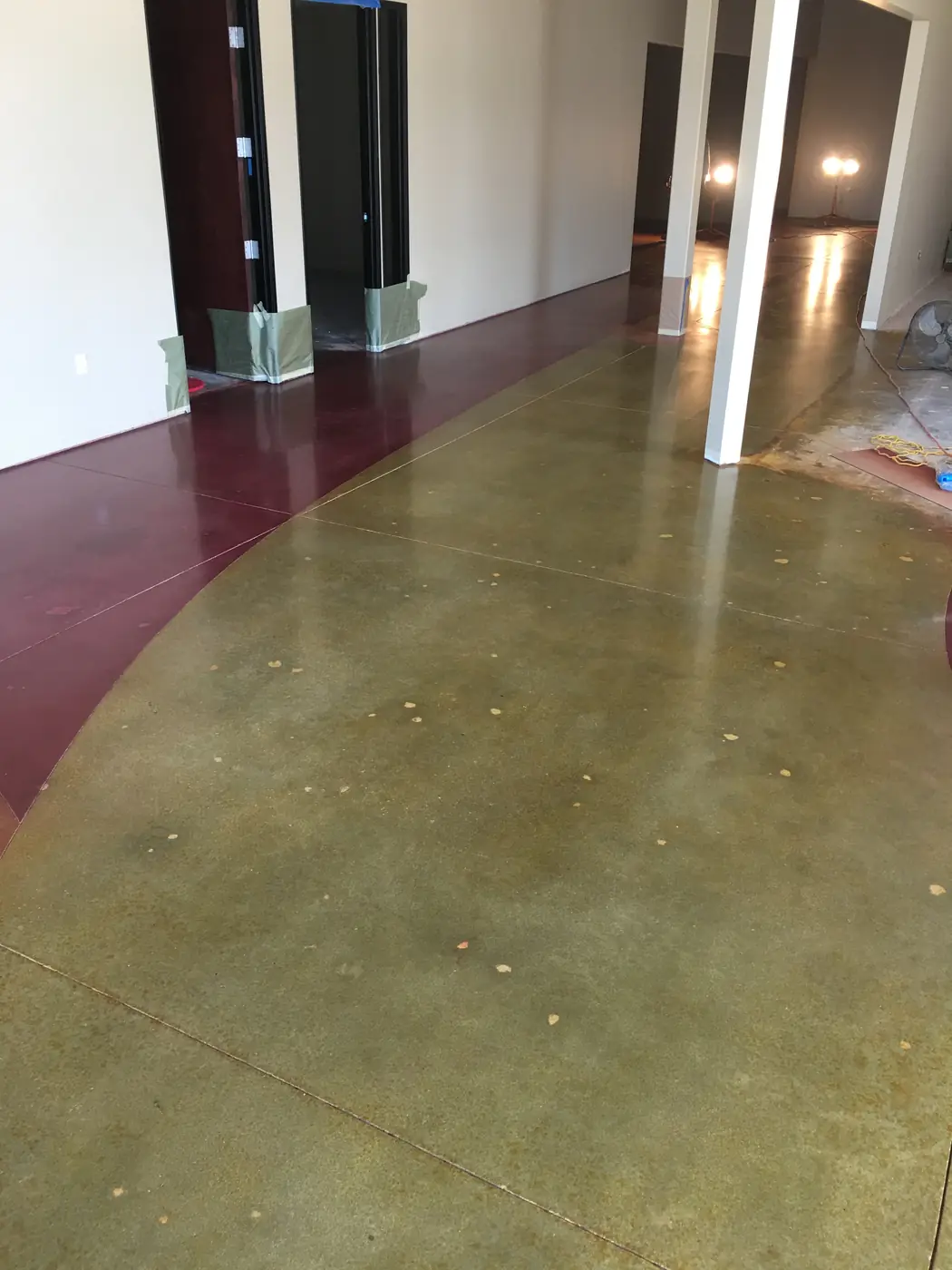 Polished floor in olive and maroon curving through a lobby