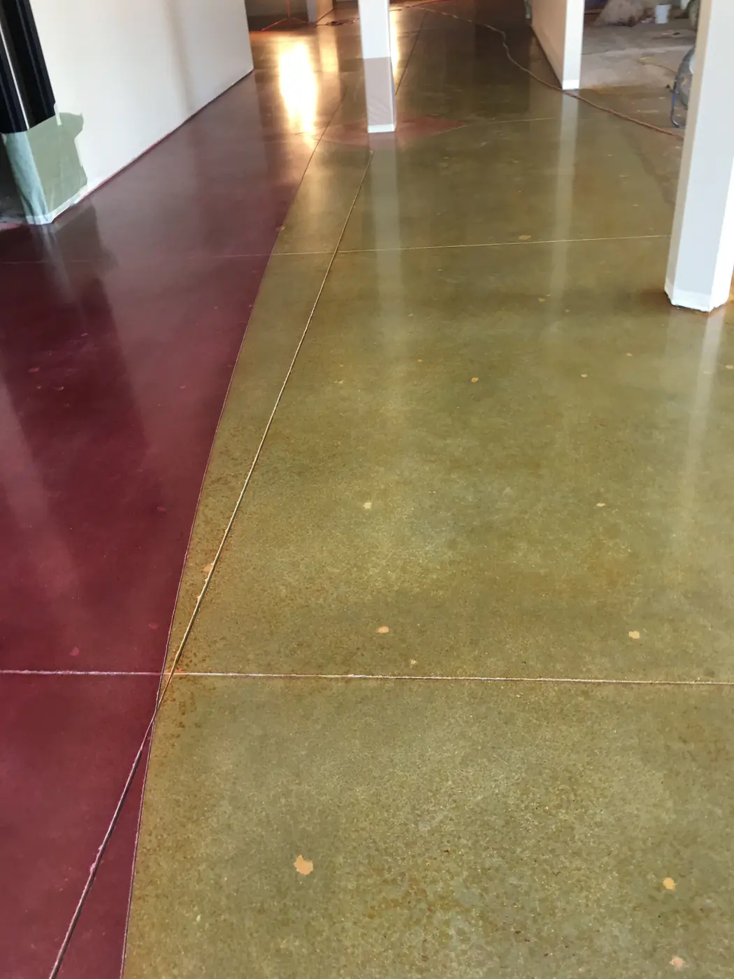 Olive and red stained polished concrete floor with a curved color break