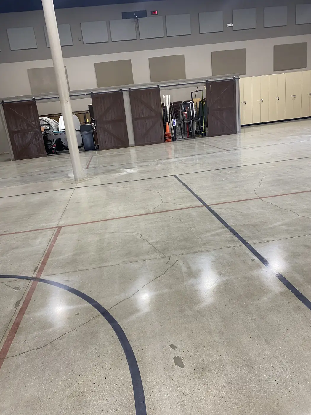 Polished concrete floor with saw-cut court markings in a multi-purpose hall