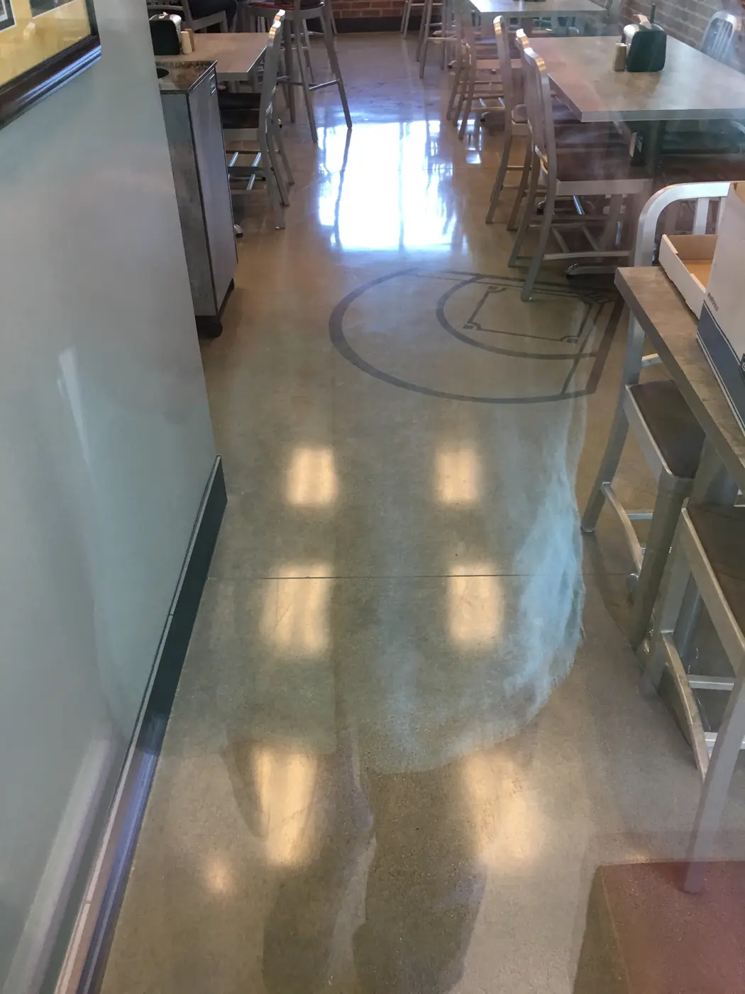 Polished concrete floor with a saw-cut circle in a cafeteria seating area