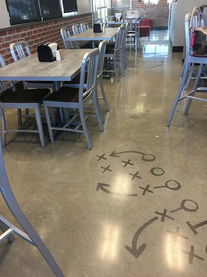 Play diagram cut into a polished cafeteria floor with bar seating above