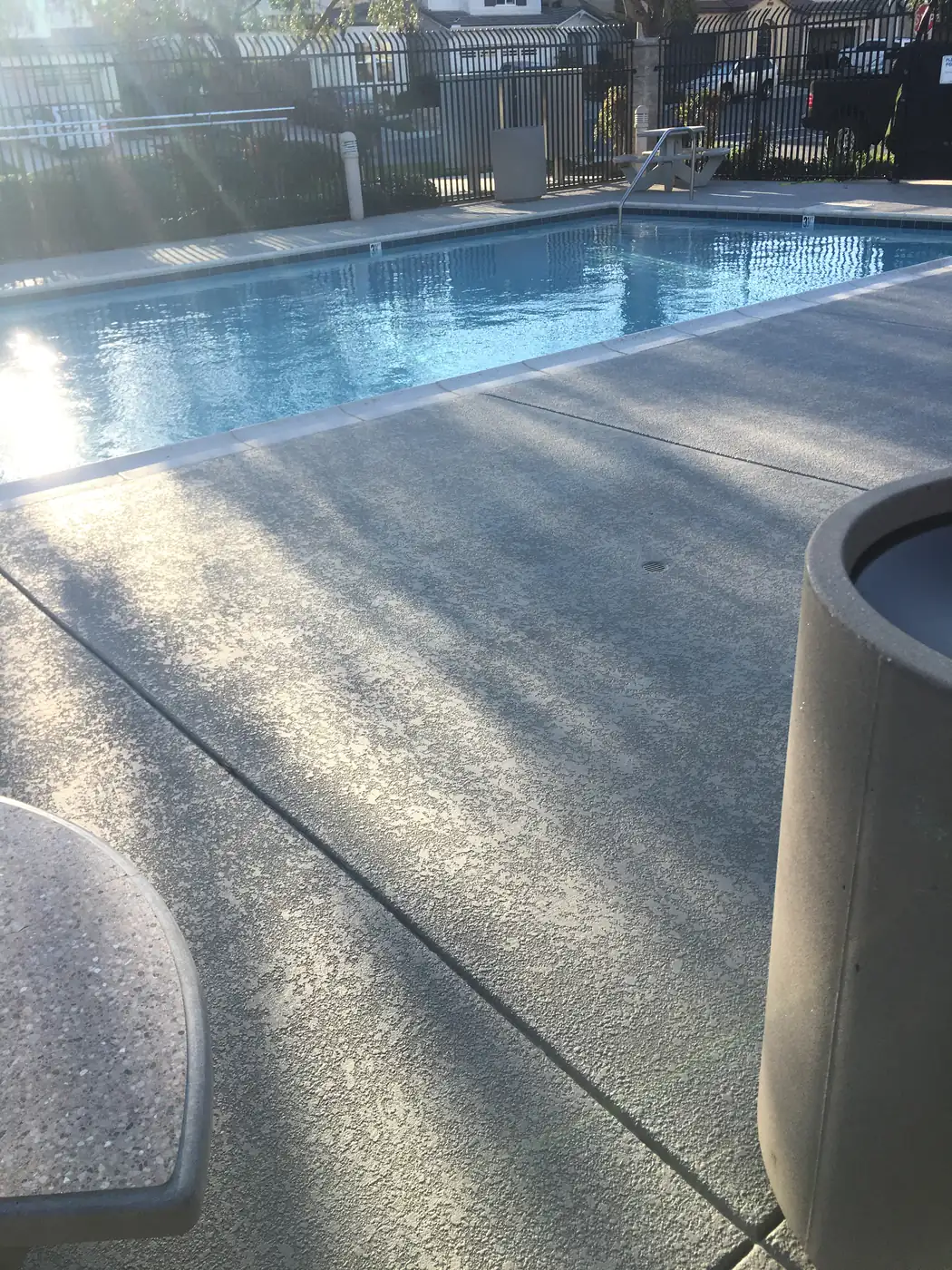 Sunlight raking across a freshly coated gray pool deck