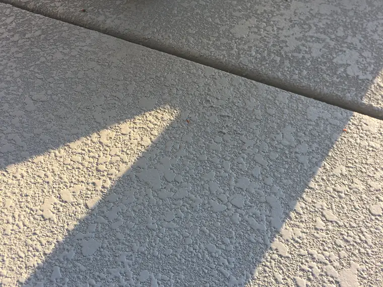 Cream knockdown textured deck with a shadow line across it