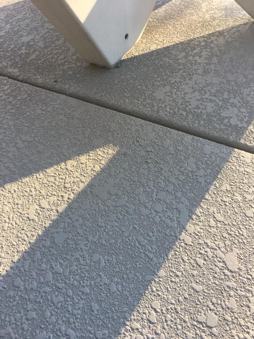 Cream knockdown textured deck with a shadow line across it