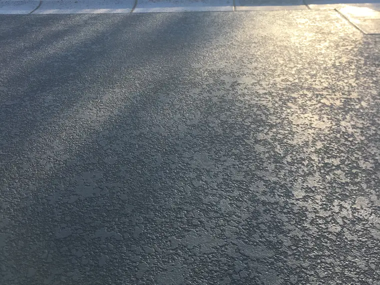 Gray pool deck with sunlight and shadow across the textured surface