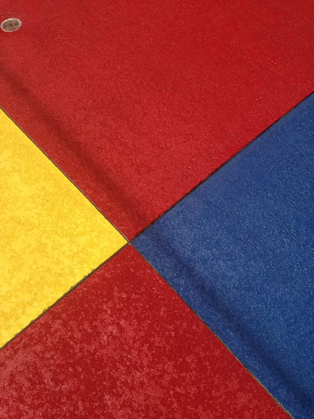 Four color blocks of textured splash pad coating meeting at a point