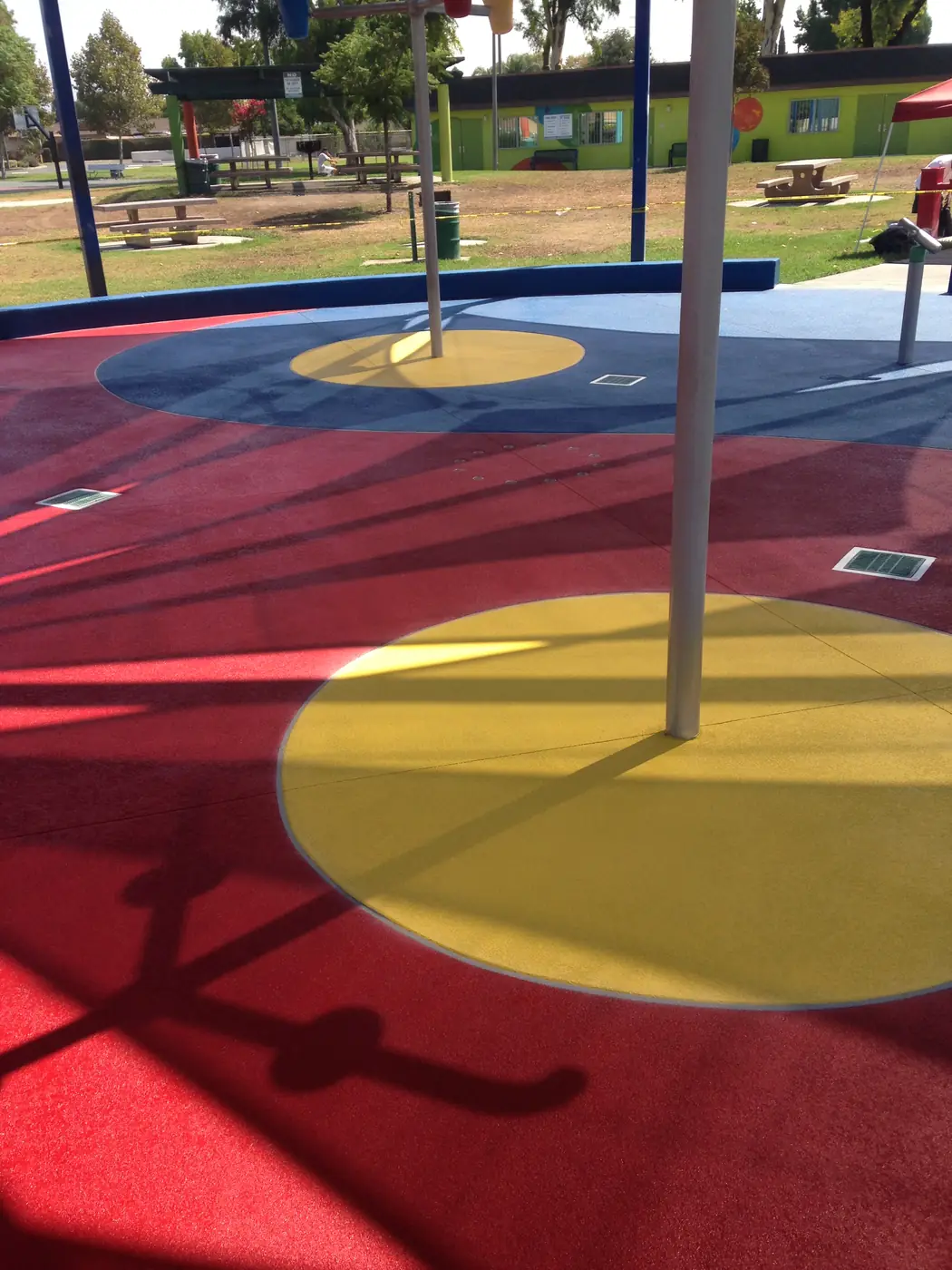 Red and yellow splash pad coating with play posts and circular targets