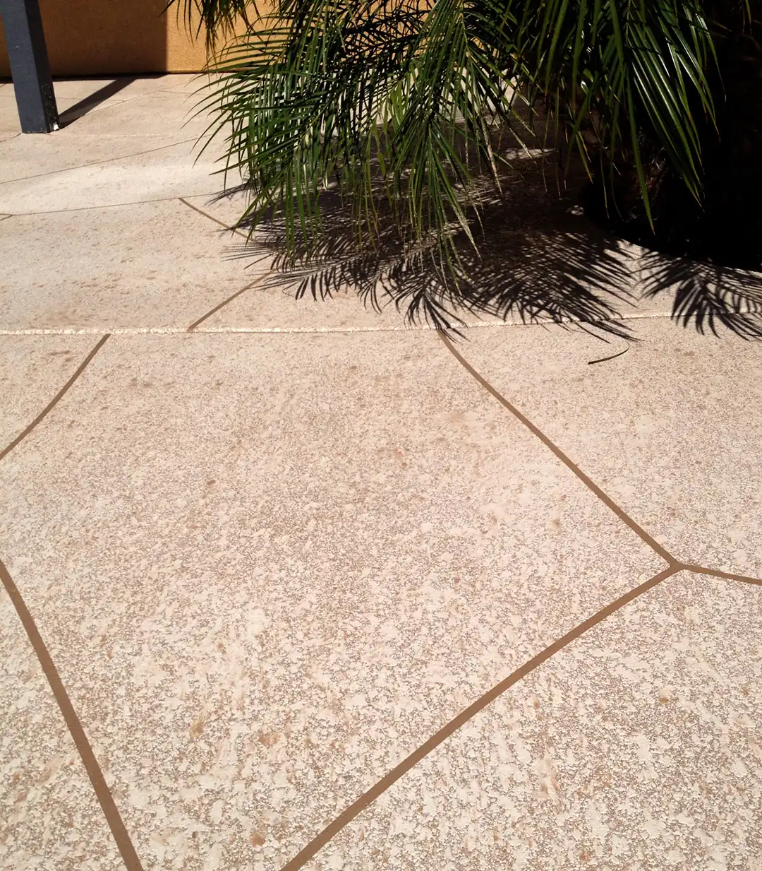 Tan textured patio broken up by scored joint lines