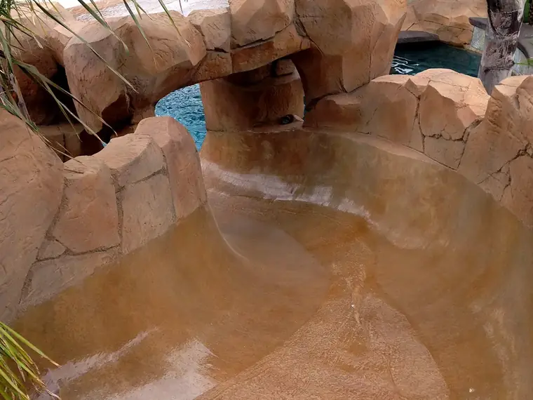 Close view of restained faux rock above the waterline of a pool