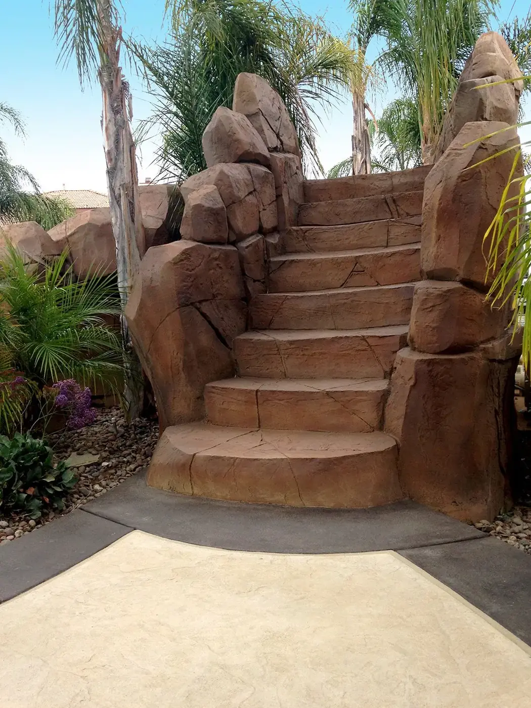 Restained rock staircase leading up beside a pool