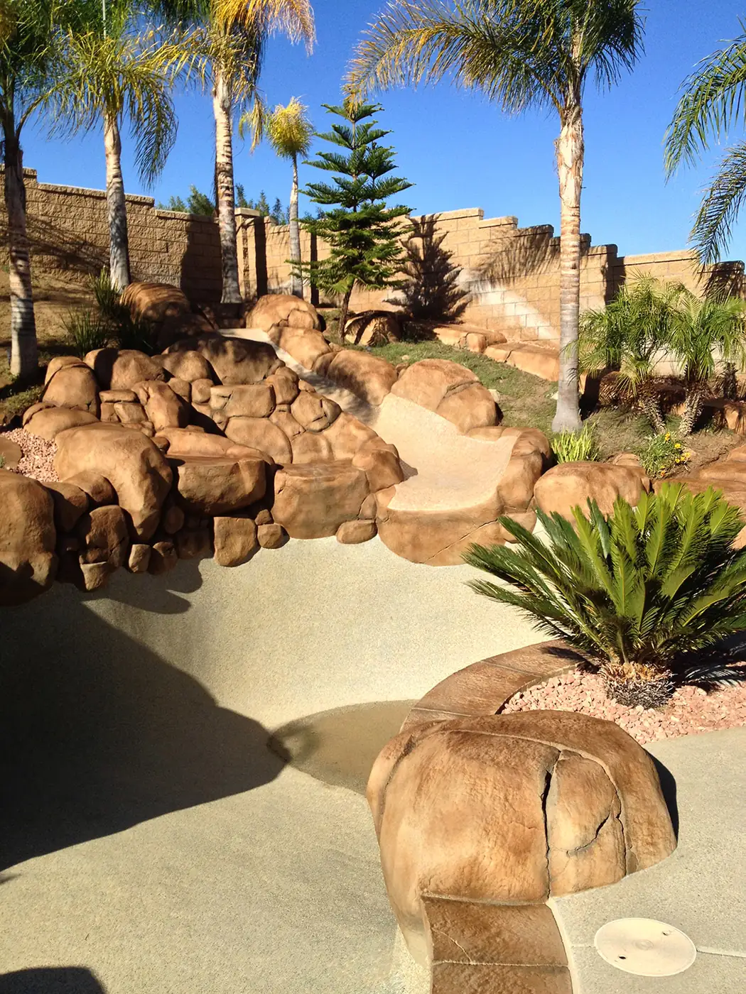Restained boulder landscape stepping down to a pool area