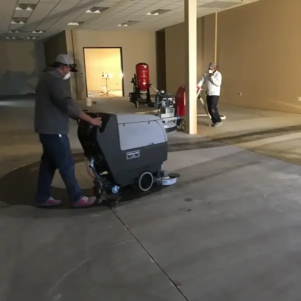 Crew running a floor machine to strip coating from a commercial room