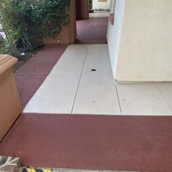 Resurfaced clubhouse walkway in cream with a deep red border band