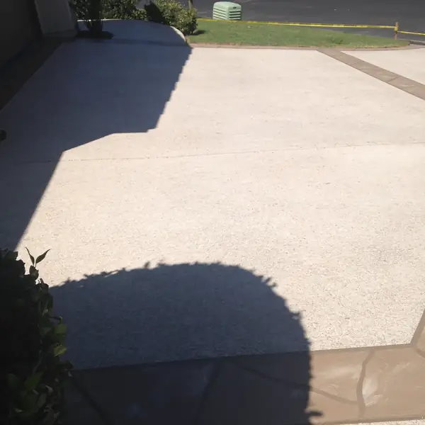 Cream resurfaced patio with a contrasting border in low sunlight