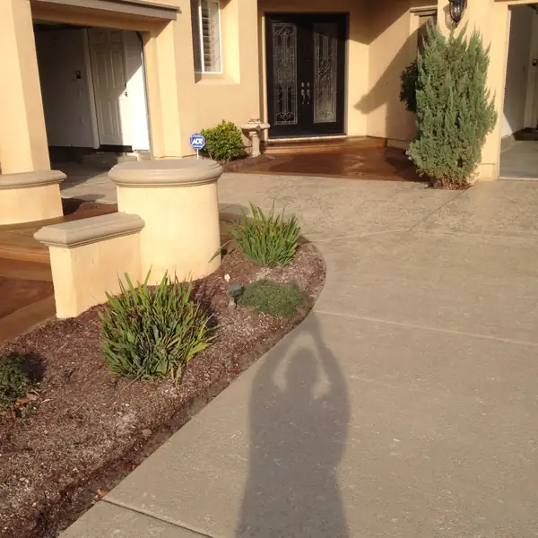 Resurfaced tan entry walkway leading to a residential front door