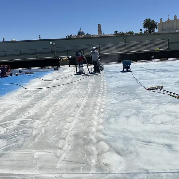 Court part-stripped, with grinding dust across the exposed concrete