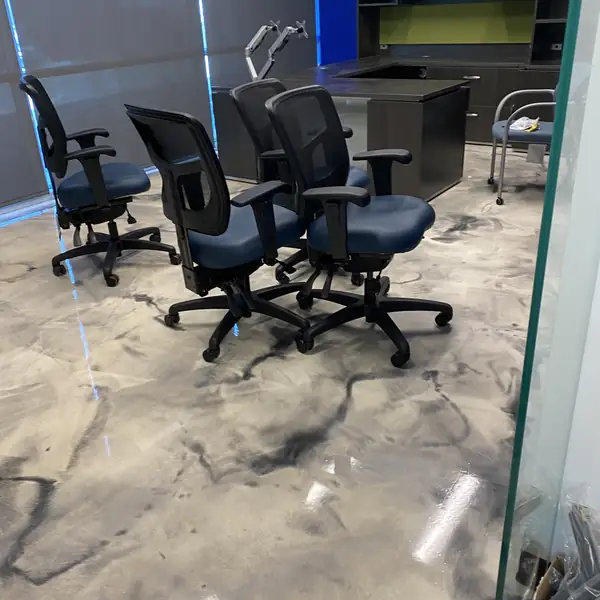 Office chairs standing on a swirled gray and white metallic epoxy floor