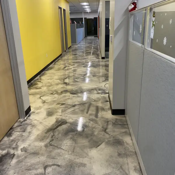 Metallic epoxy corridor between a yellow wall and office cubicles
