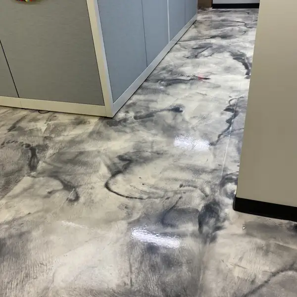 Swirled metallic epoxy floor running between office cubicle partitions