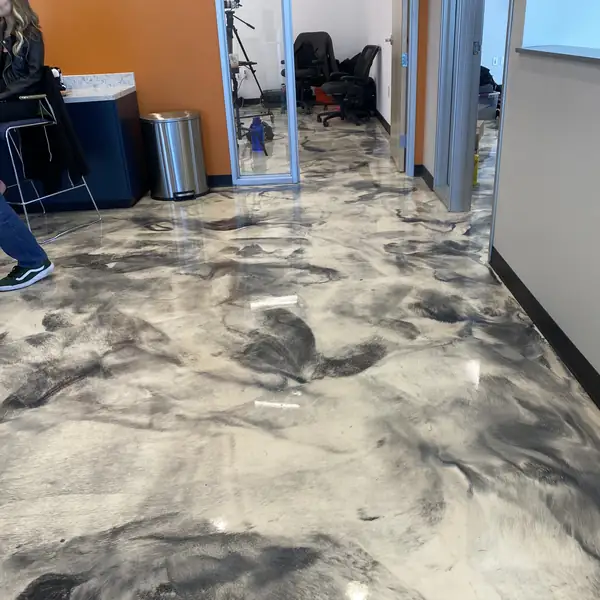 Metallic epoxy floor beside an orange accent wall in an office reception