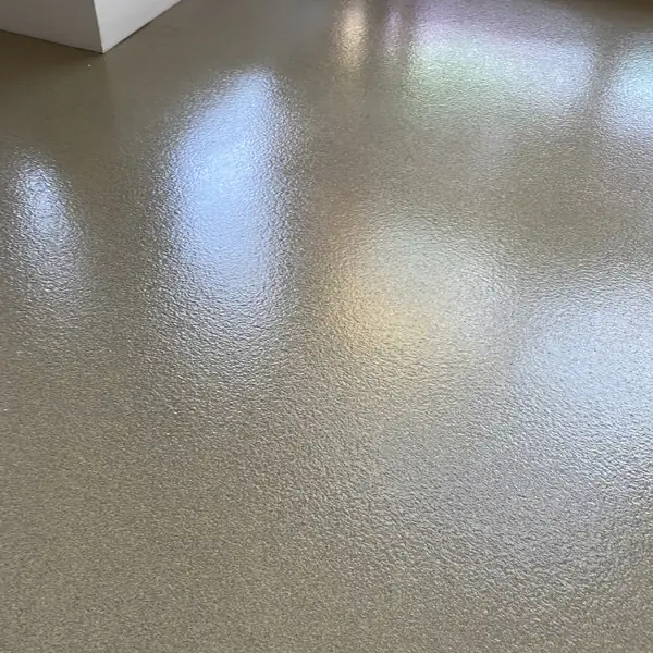 Gray flake epoxy floor with a timber pallet resting at the edge