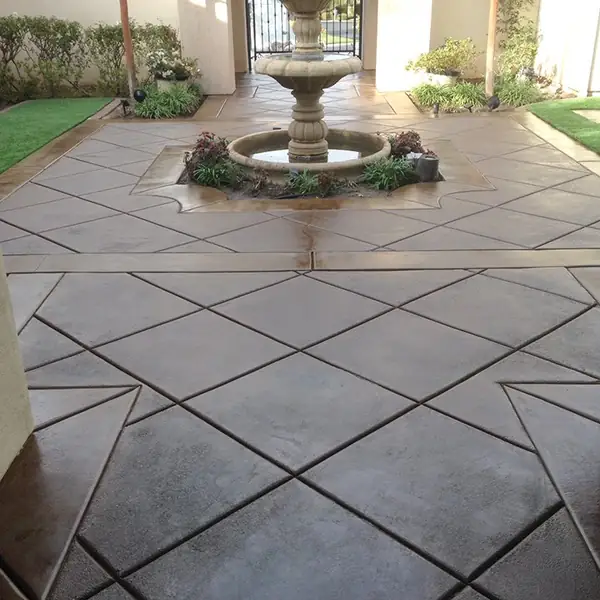 Diamond-scored stained courtyard leading to a tiled fountain