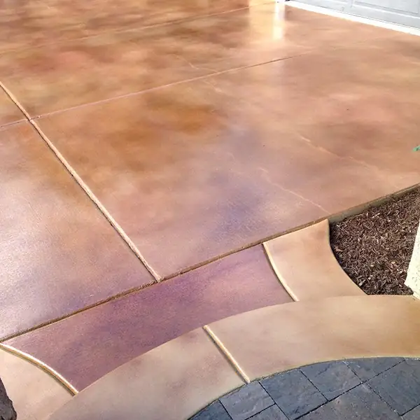 Mauve stained driveway edged with a contrasting paver border