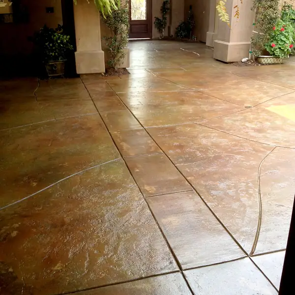 Stained entry patio scored in a tile pattern beside a stucco column