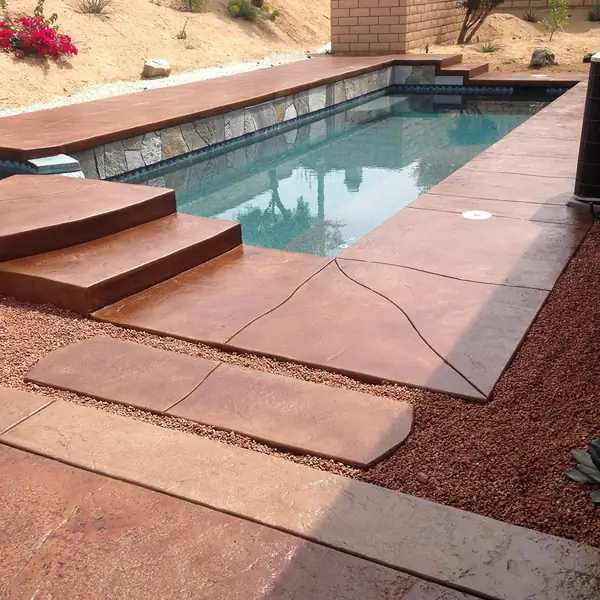 Red stained pool deck and steps set in a red rock landscape