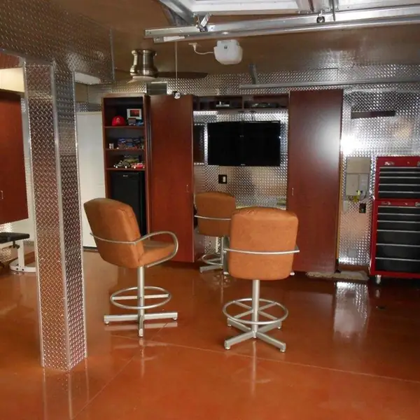 Home workshop garage with a copper-stained floor, bar stools and a red tool chest