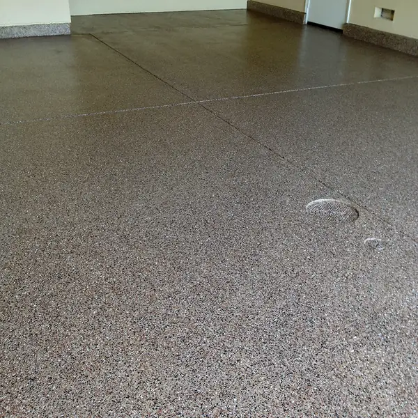 Gray flake epoxy garage floor with a coved edge along the wall