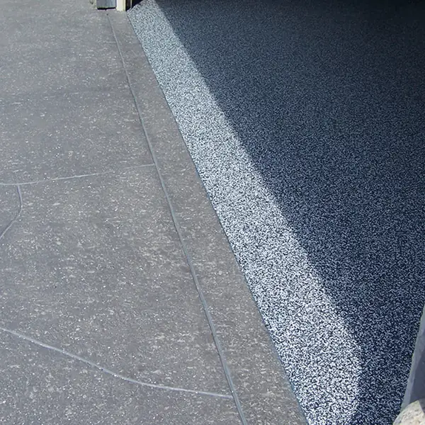 Blue and gray flake epoxy meeting a clean coved edge in a garage