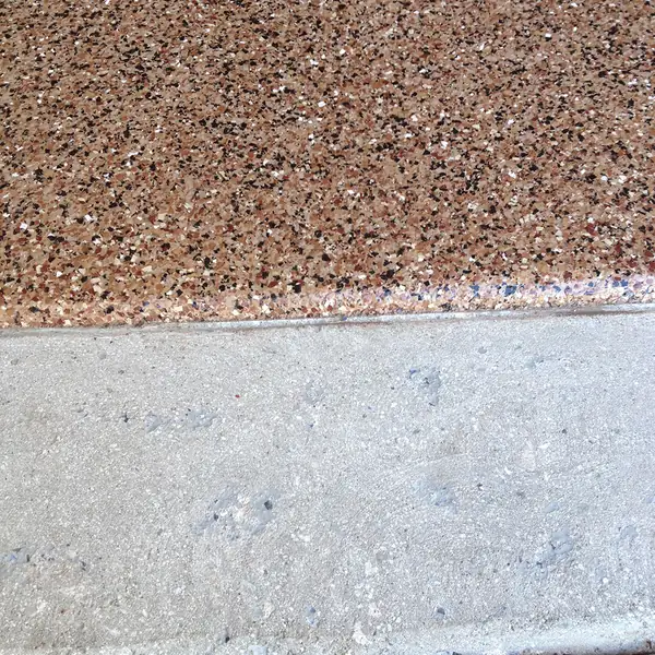Brown flake epoxy wrapping the nose of a garage step