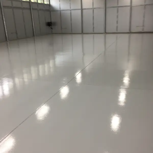 White high-gloss epoxy floor in a clean industrial bay