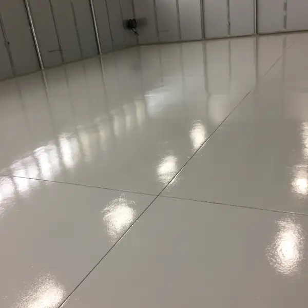 Light gray epoxy floor running the length of a clean warehouse