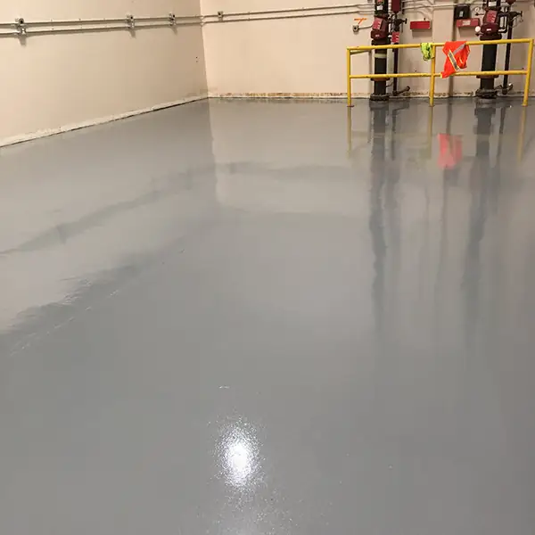 Gray epoxy floor stretching through an empty warehouse