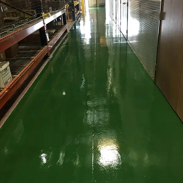 Green epoxy aisle running between tall warehouse racking