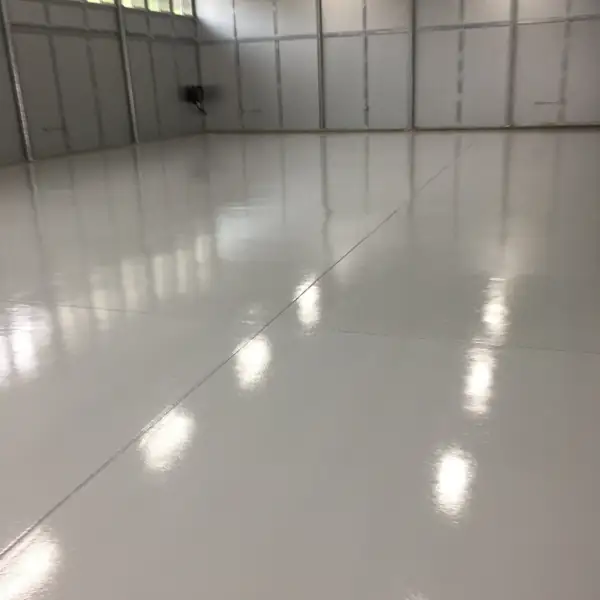 White gloss epoxy floor reflecting daylight in a warehouse