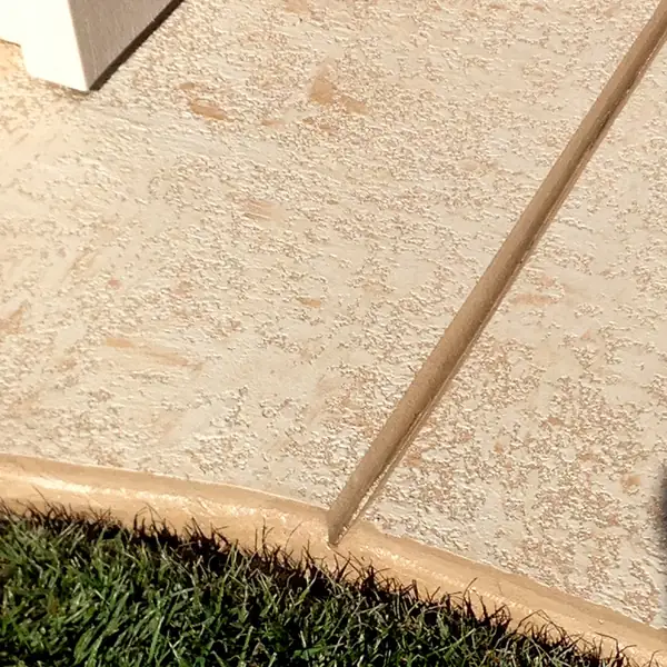 Light tan microtopping meeting a lawn edge with a contrasting border