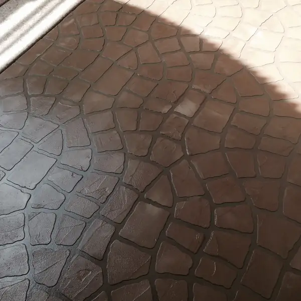 Brown stamped concrete overlay in a rounded cobblestone pattern
