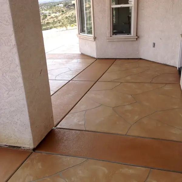Terracotta stamped overlay patio running along the side of a house